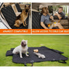 A black waterproof dog car seat cover is shown on a lawn, demonstrating compatibility with an armrest and allowing access to 