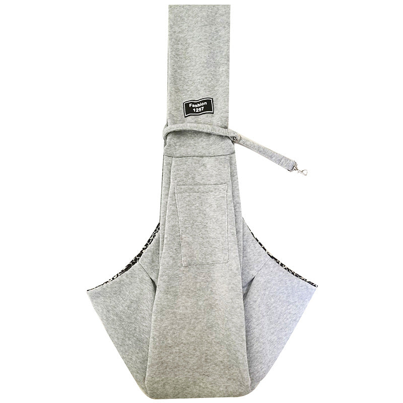 A gray adjustable crossbody dog sling carrier with a black patterned trim.