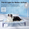 A black and white dog is lying on a blue cooling pet mat with a white background.