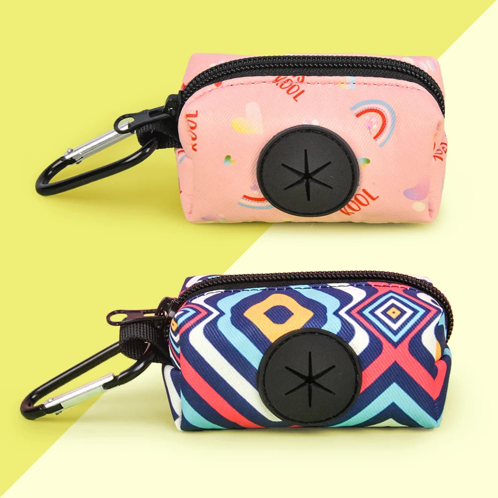 A pink zippered pouch with a black button and a rainbow pattern is shown next to a patterned blue and white bag holder.
