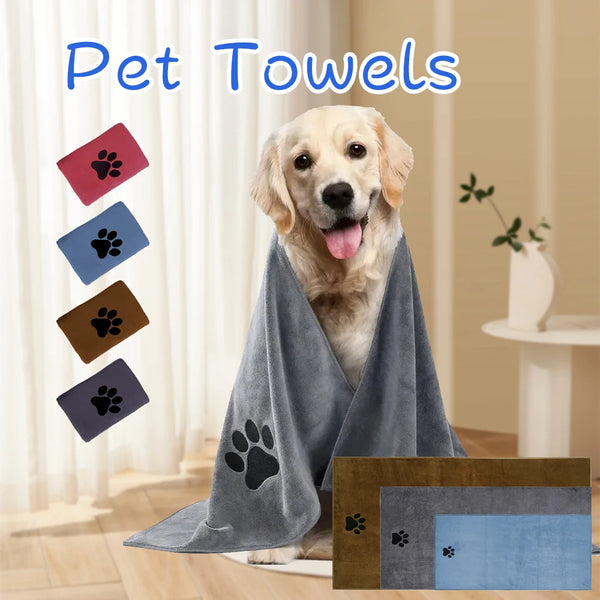 A golden retriever dog wearing a gray pet towel with an embroidered paw print.