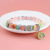 A colorful lace pet collar with a pendant is displayed on a white plate.