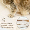 A fluffy tabby cat is resting on a cream-colored fabric, demonstrating the comfort of a wall mounted cat bed.