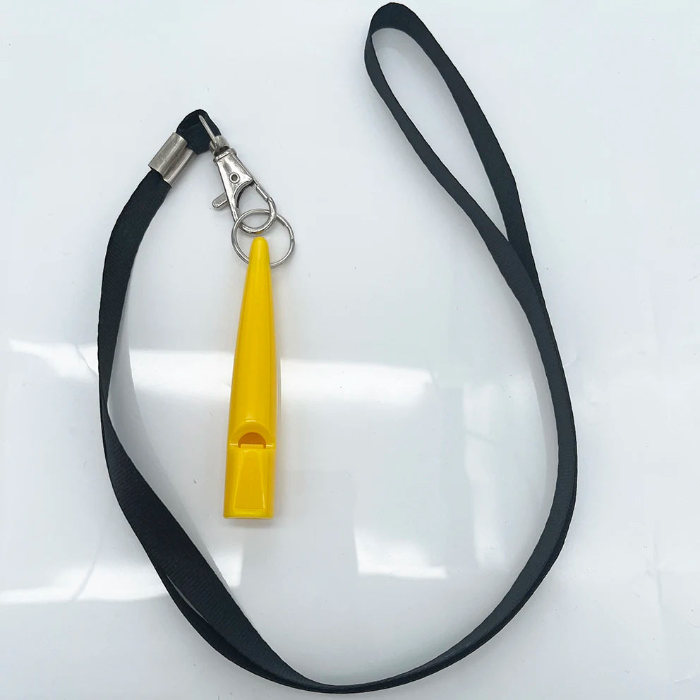 A yellow ultrasonic dog whistle attached to a black lanyard and metal clip on a white surface.