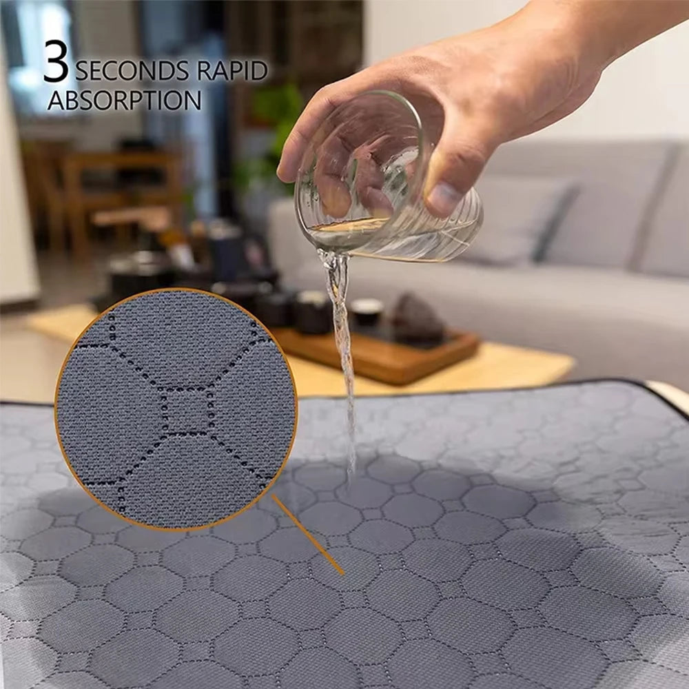 A hand pours liquid from a glass onto a gray, hexagonal fleece liner for small pets.
