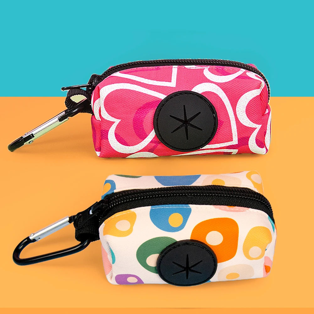 A pink and white patterned stylish dog poop bag holder with a black circular opening is shown on an orange background.
