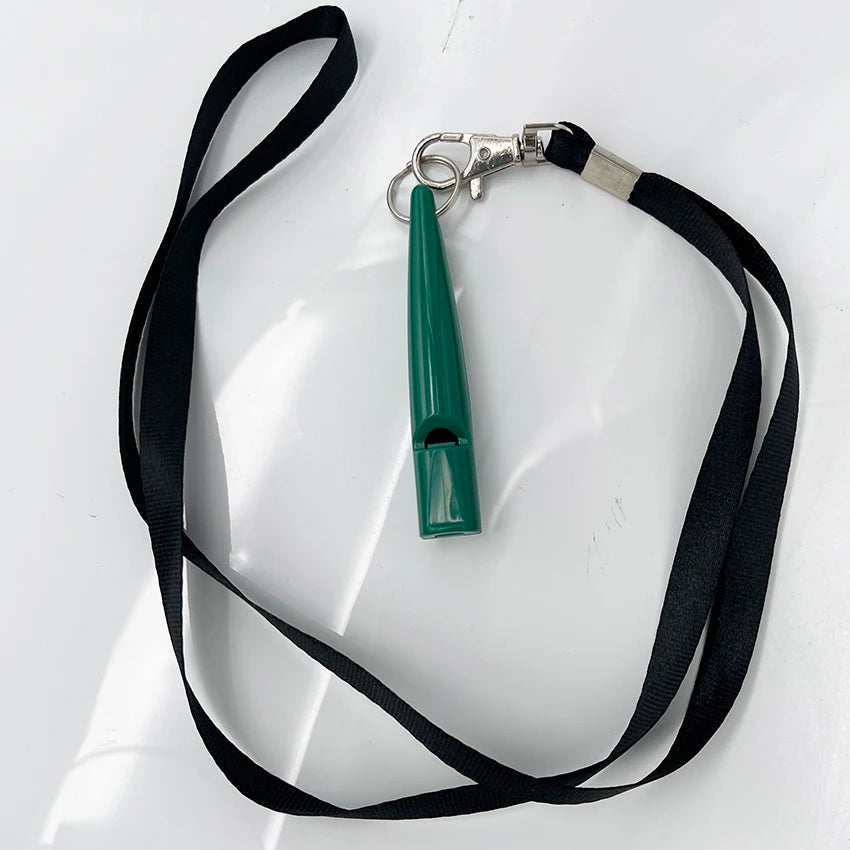 A green ultrasonic dog whistle attached to a silver clip and black lanyard.
