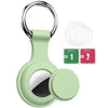 A silicone protective cover for an AirTag attached to a keychain, shown with separate wet and dry wipes.