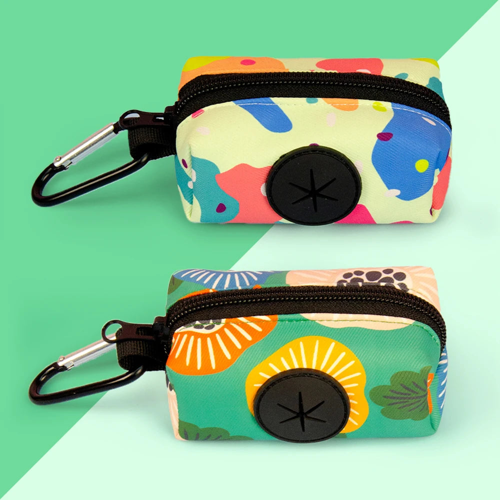 A colorful, patterned fabric poop bag holder with a black strap and clip.
