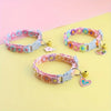 Pink floral lace pet collar with a gold pendant displayed on a light yellow background.