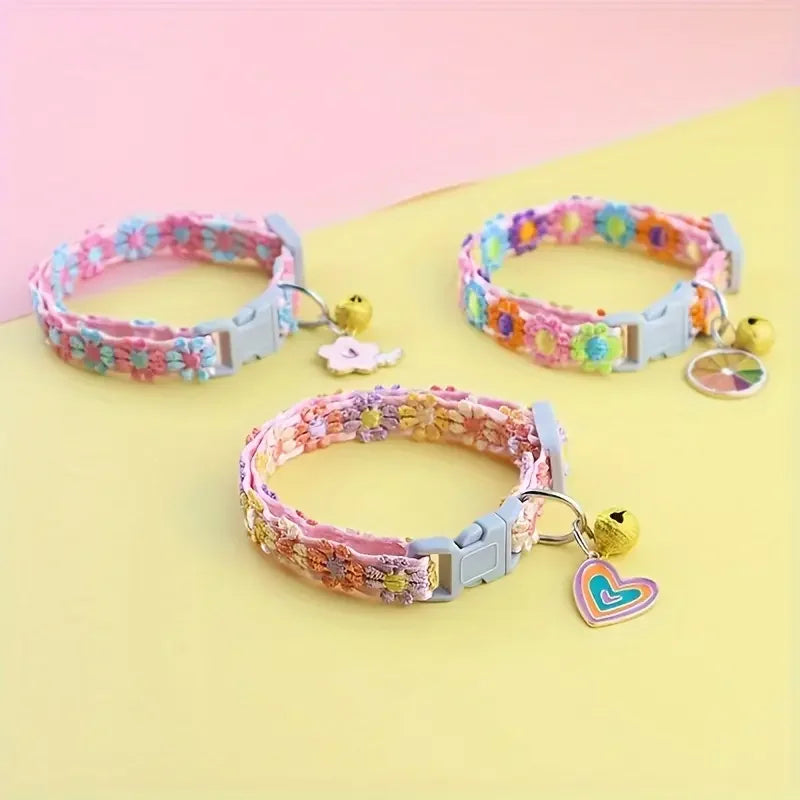 Pink floral lace pet collar with a gold pendant displayed on a light yellow background.
