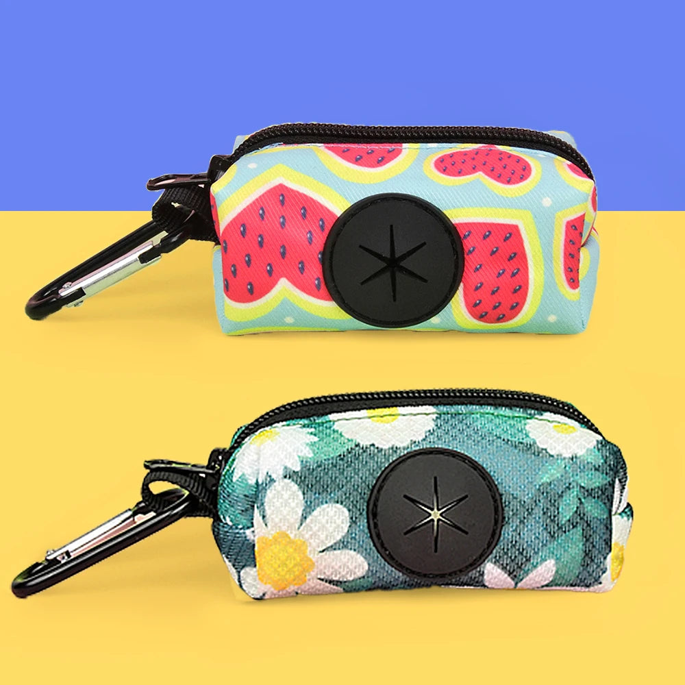 A colorful, patterned pouch designed to hold dog poop, featuring a pink and green fruit design.