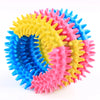 A colorful rubber chew toy with jagged teeth in yellow, pink, and blue.