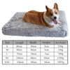 A fluffy orange and white dog is resting on a rectangular gray orthopedic pet bed.