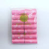 A pack of 14 rolls of pink paw print dog waste bags with a dispenser inside a clear plastic bag.