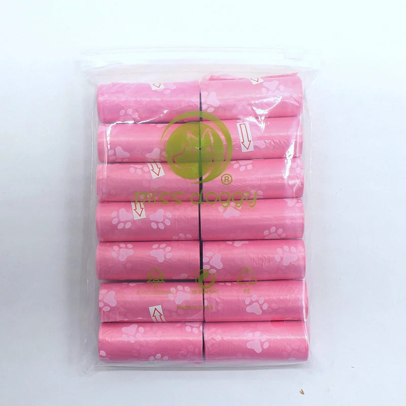 A pack of 14 rolls of pink paw print dog waste bags with a dispenser inside a clear plastic bag.