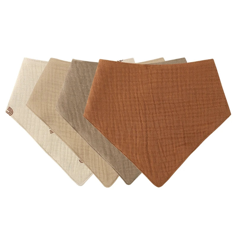 A pack of three soft cotton baby bibs in shades of beige and brown laid diagonally.