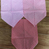 Three folded pink and red striped cotton pet bandanas for dogs and cats