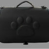 Black leather pet carrier bag featuring a paw print design and a handle.