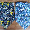 Two folded blue and white floral patterned cotton pet bandanas for dogs and cats