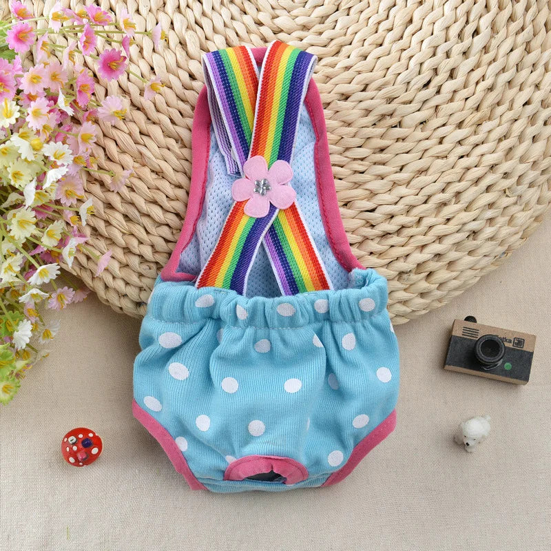 A colorful striped physiological dog underwear set with pink trim is displayed on a beige fabric background.