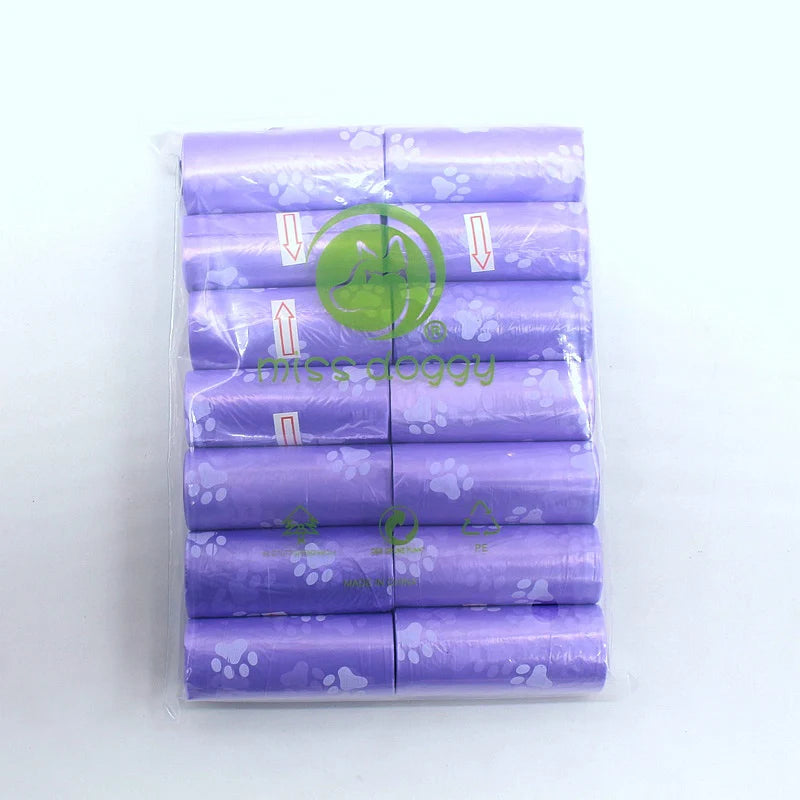 A pack of 14 rolls of purple paw print dog waste bags with a dispenser.