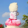 A fluffy white dog dress with pink accents and a pink ruffled skirt.