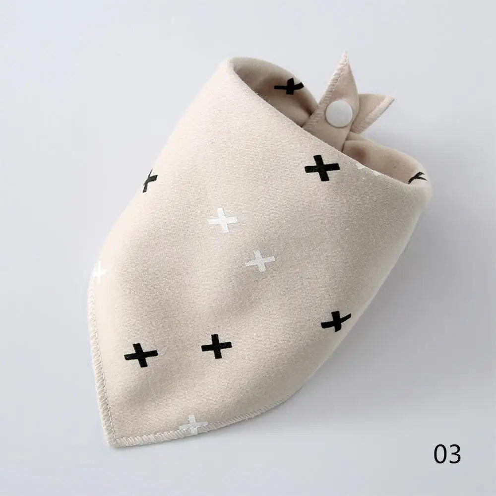 A beige cotton pet bandana with black cross patterns, folded and displayed on a white background.