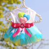 A pink and blue tulle dress for a dog featuring colorful fabric flowers and pearl accents.