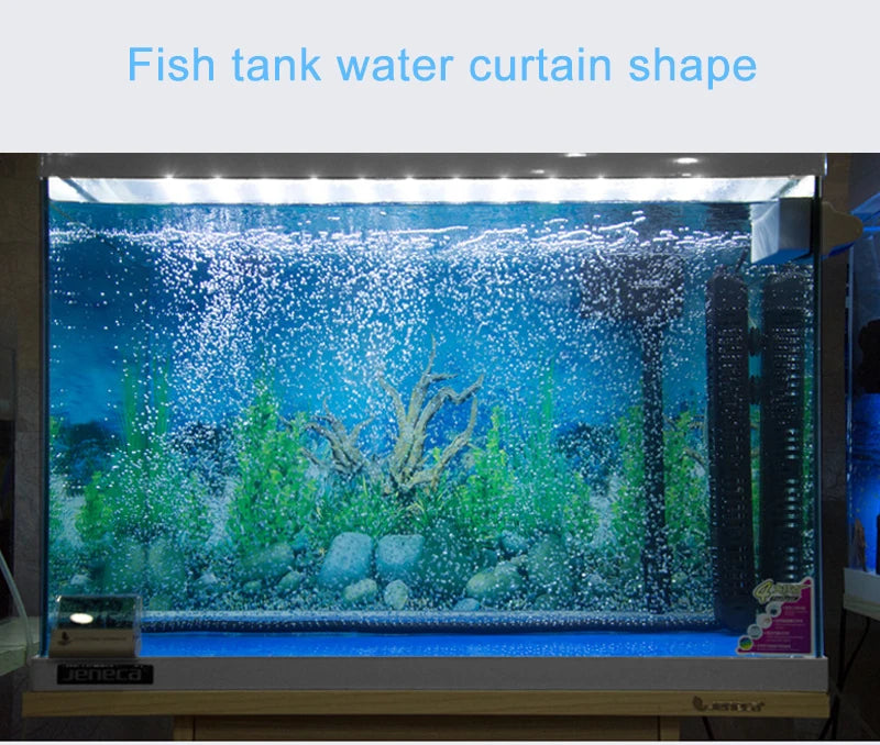 A glass fish tank displaying a vibrant underwater scene with aquatic plants and rocks.