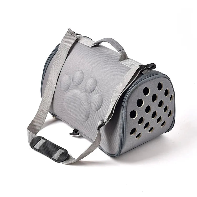 A gray breathable pet carrier bag with a paw print design and straps.