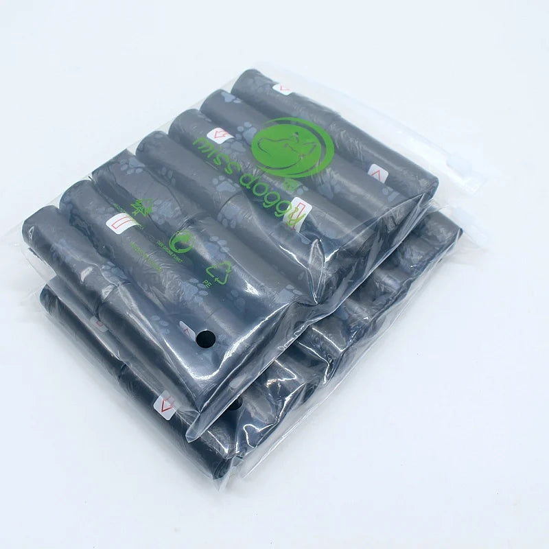 A pack of 14 rolls of black paw print dog waste bags with a dispenser visible in clear plastic packaging.