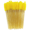A bundle of yellow disposable eyelash brushes for makeup application