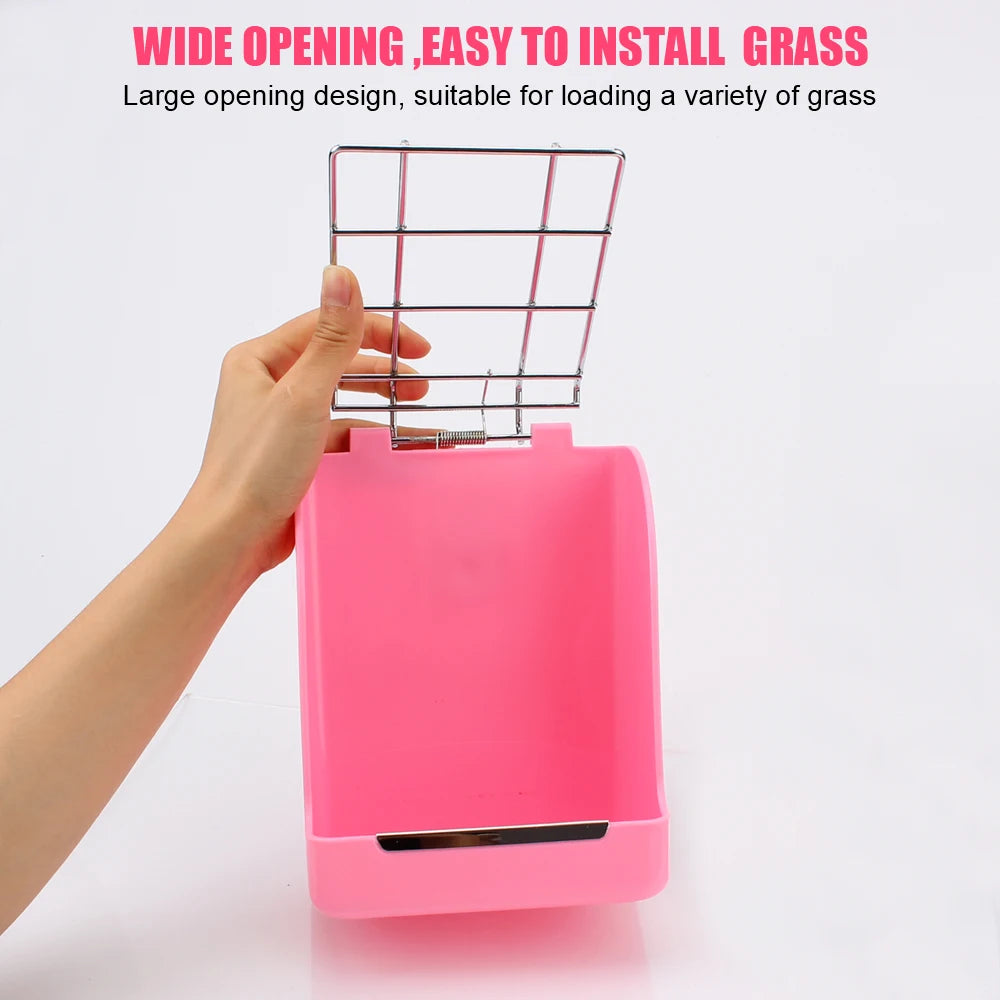 A hand is holding a pink rabbit hay and food rack with a wire mesh opening for feeding grass.