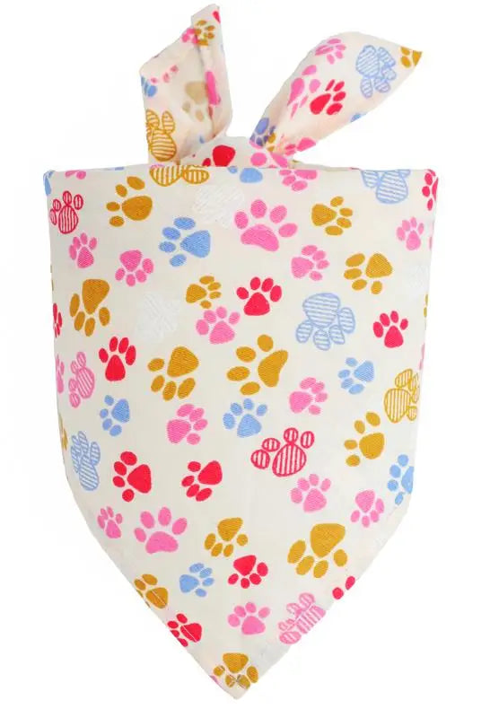 A pink and yellow patterned cotton bandana with a fabric bow for a pet.