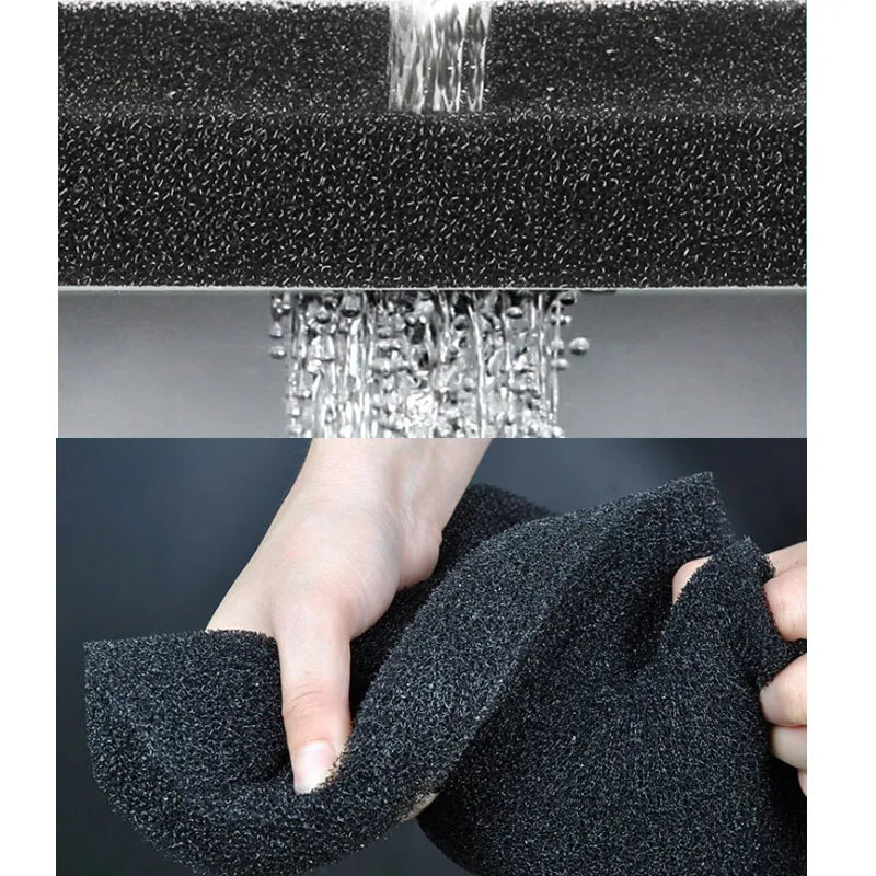 A hand is squeezing a black, porous sponge filter used for biochemical aquarium filtration.