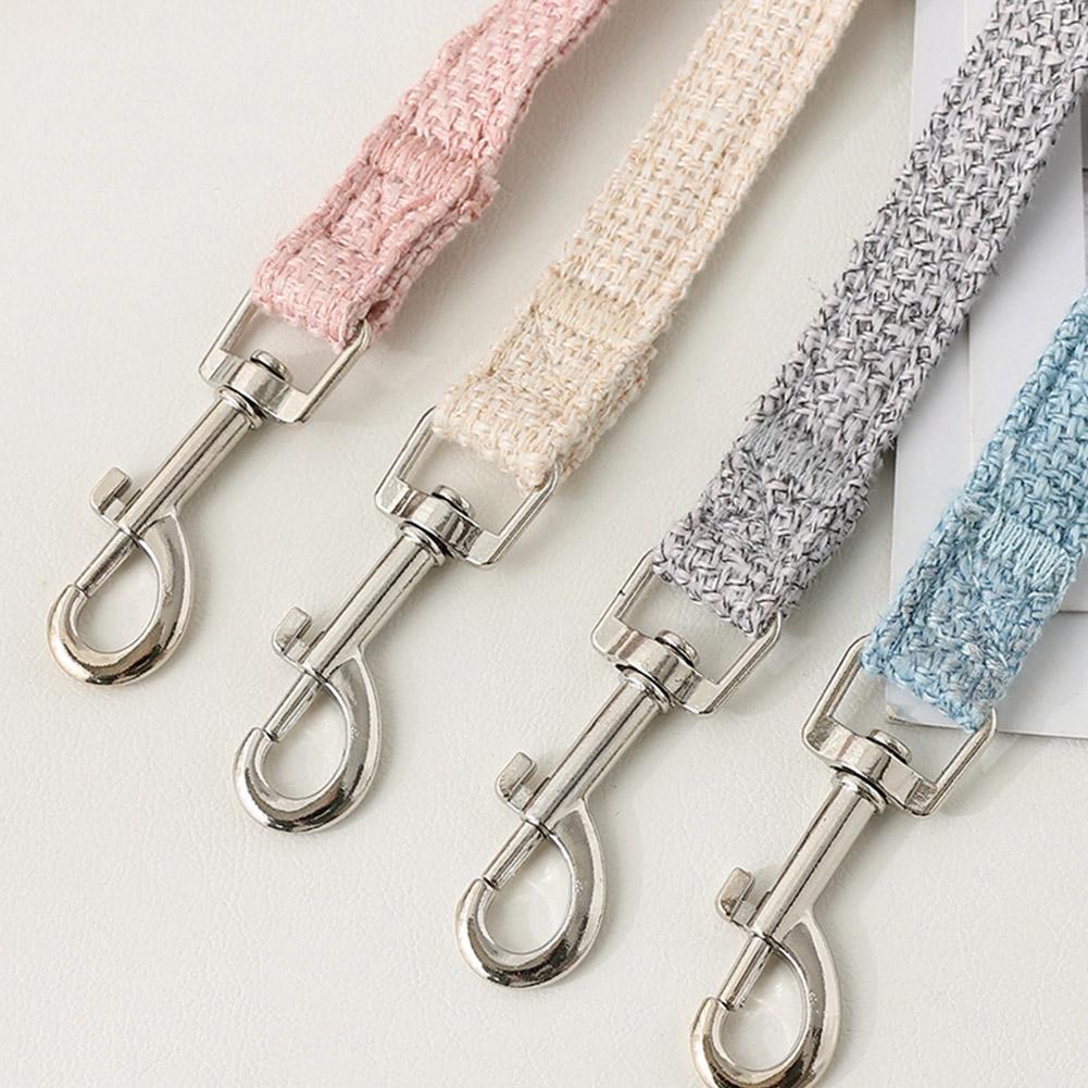 A collection of pet leash harnesses in pink, beige, and gray woven fabric.