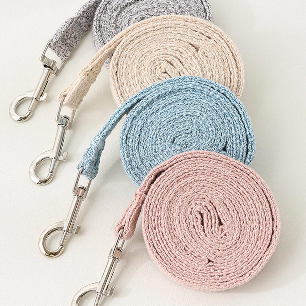 A stack of pet leash harnesses in various neutral tones including gray, beige, and blue.
