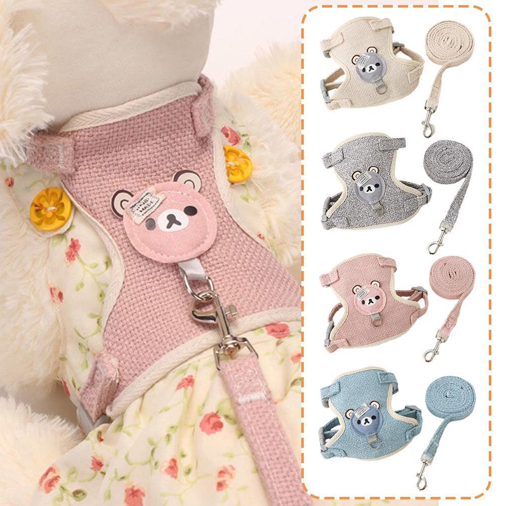 A collection of pink, gray, and blue pet leash harnesses for dogs and cats displayed on a fluffy garment.