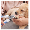 A person is using stainless steel pet nail clippers on a light-colored puppy's paw.