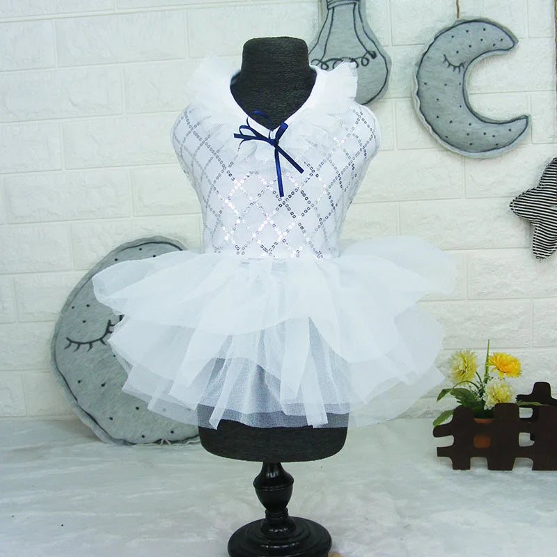 A black dress form displays a white sequined princess dog dress with a sheer tulle skirt against a light background.