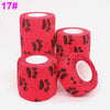 Three rolls of red knitted elastic bandage tape with black paw print pattern