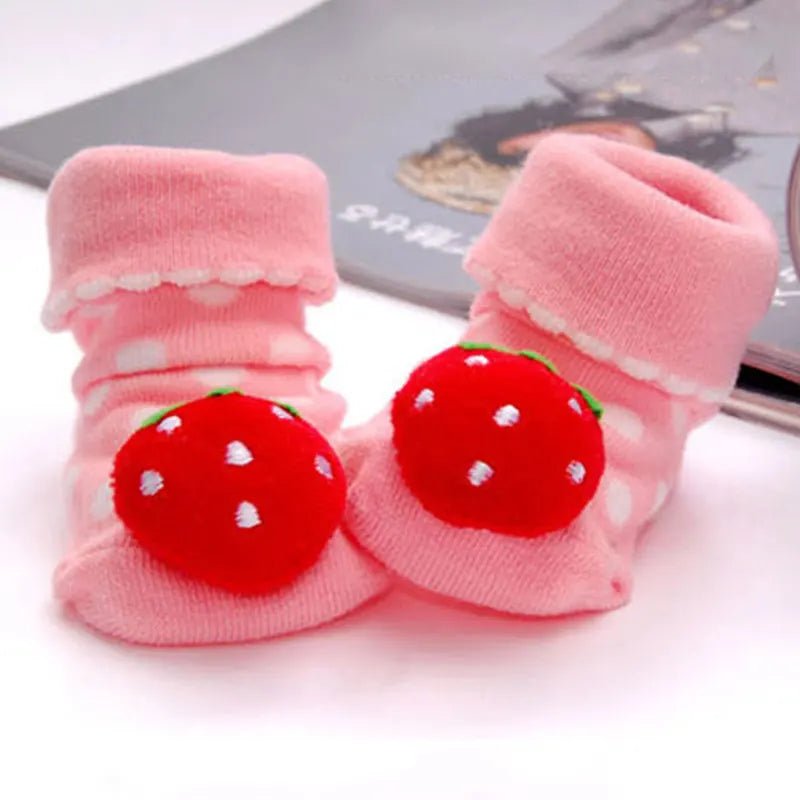 Paar rosa Strickbaby-Socken mit roten Erdbeer-Designs für Kleinkinder