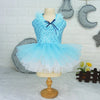 A light blue sequined princess dress for a puppy displayed on a mannequin against a white brick wall.