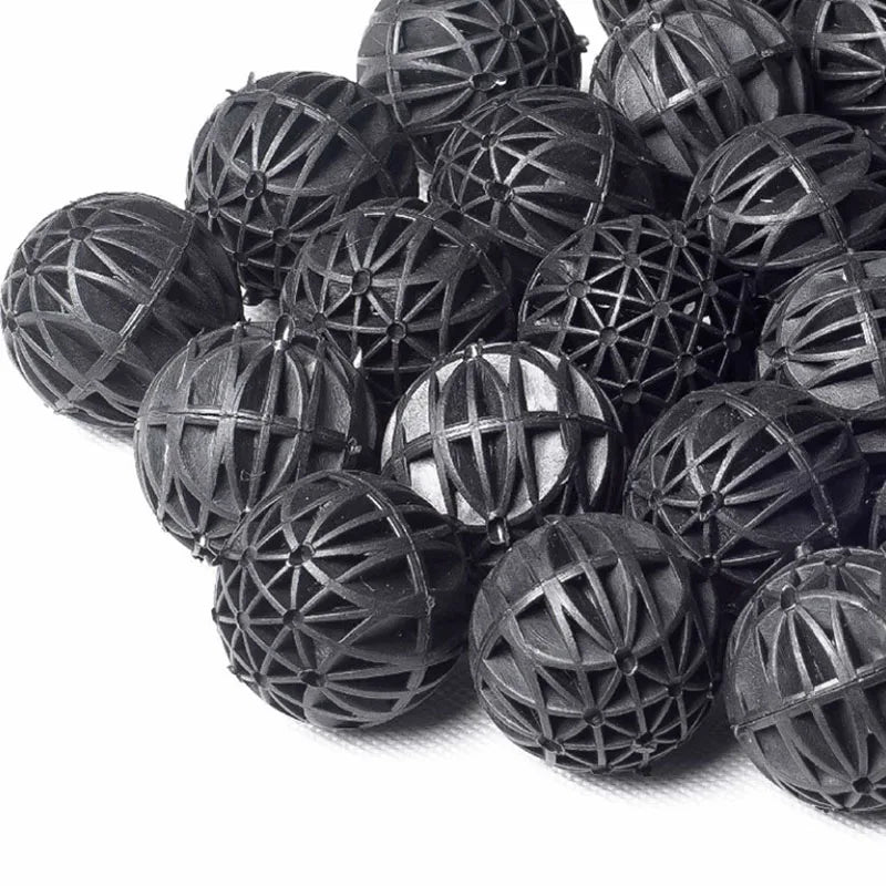 A pile of black aquarium bio balls used for water filtration.