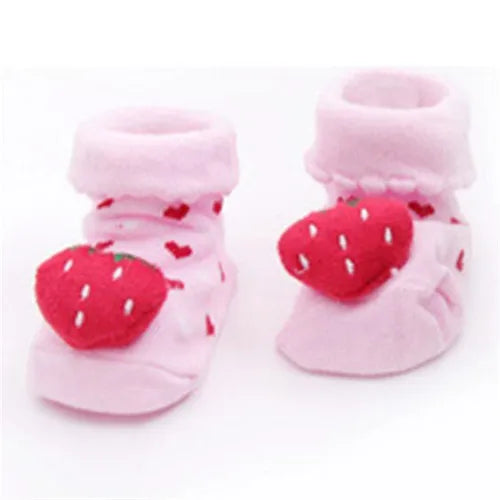 Paar rosa flauschiger Baby-Socken mit roten Erdbeermustern für Kleinkinder