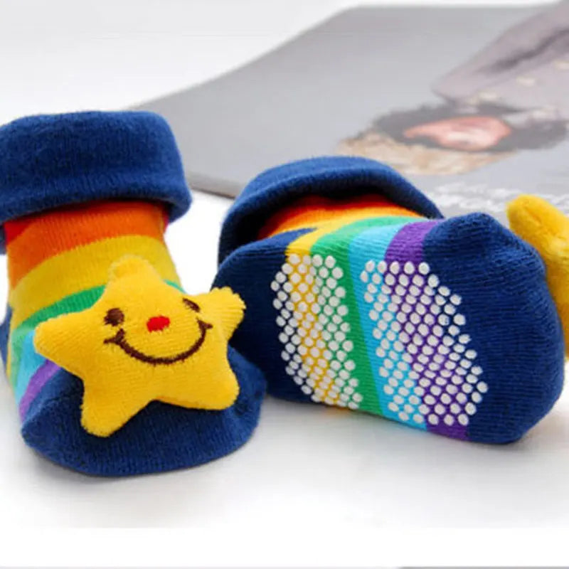 Ein Paar bunte, gestreifte Baby-Socken mit gelbem Sternmuster für Kleinkinder.