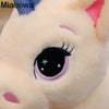 Close-up of a light pink unicorn plush toy with black eyes and a blue detail on the ear.