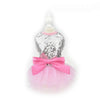A pink sequined dog dress with a bodice and a large pink bow displayed on a white mannequin.