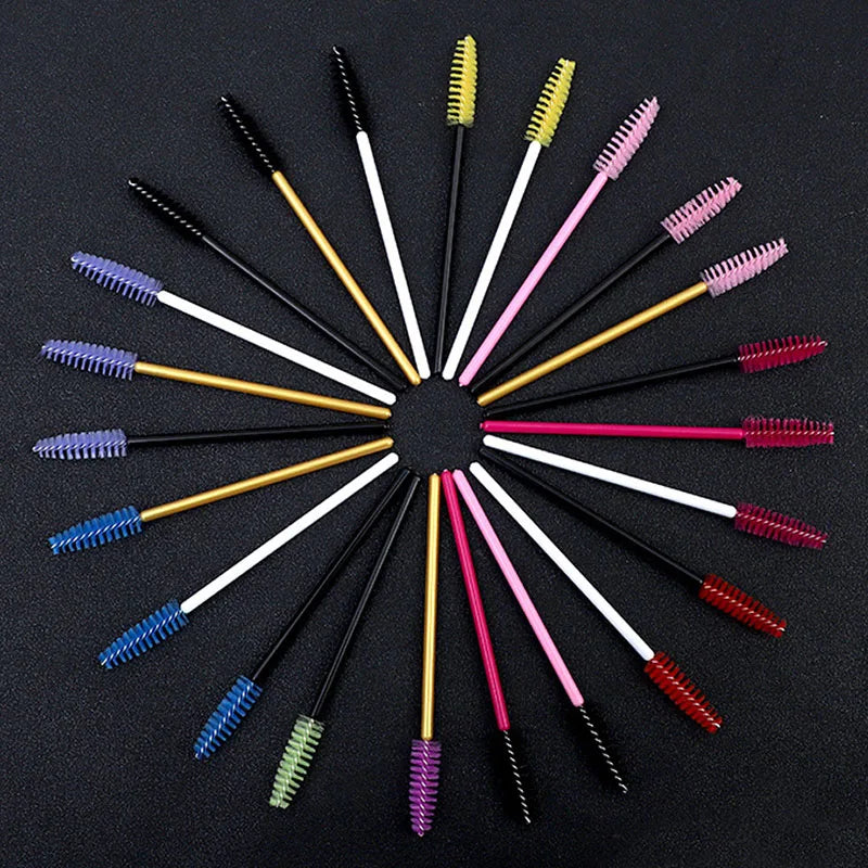 A collection of various disposable eyelash brushes in different colors and shapes arranged radially.